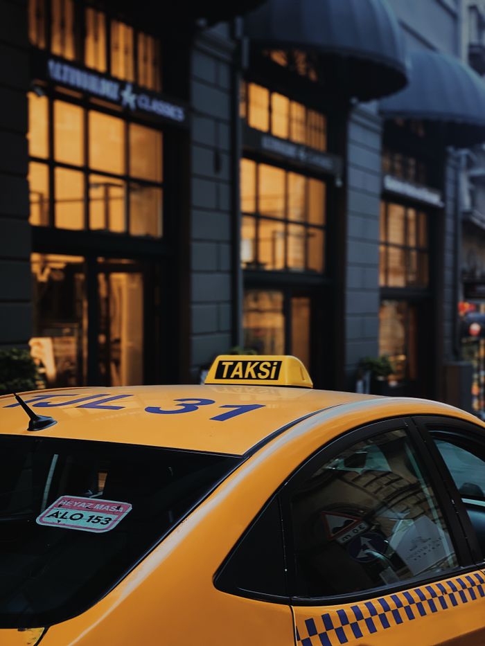 A yellow taxi parked on a lively street in Istanbul, capturing urban atmosphere.
